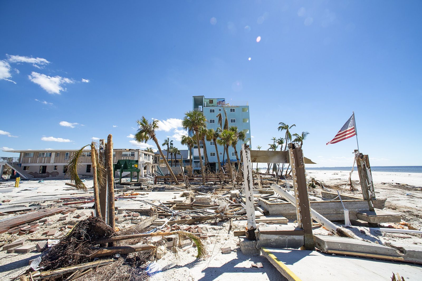 American flag on a pole surrounded by storm debris after Hurricane Ian